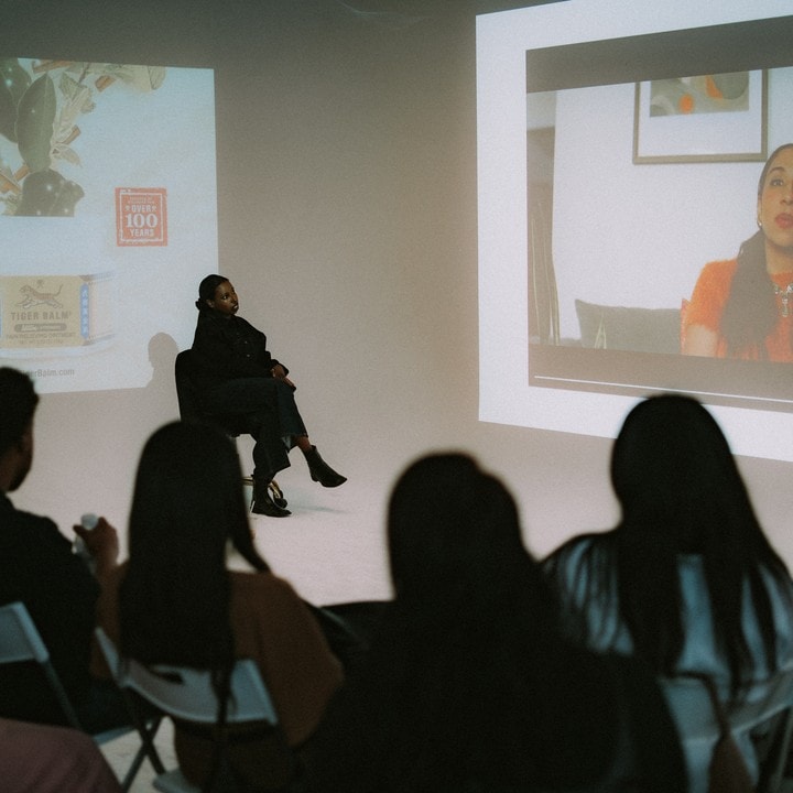 A speaker on screen as the audience watches