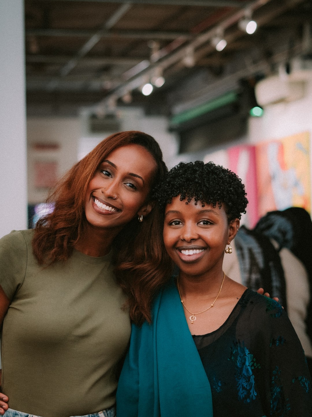 Two attendees smiling together in the gallery